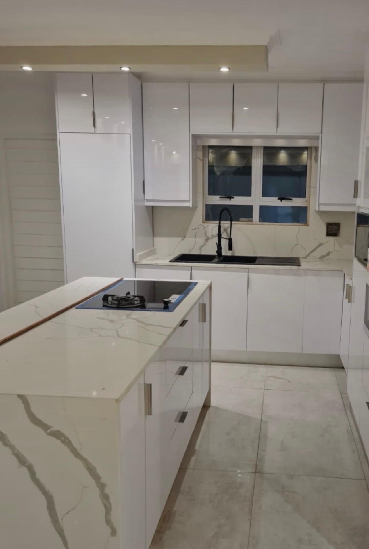 Modern kitchen with marble stone tops and gloss cupboards